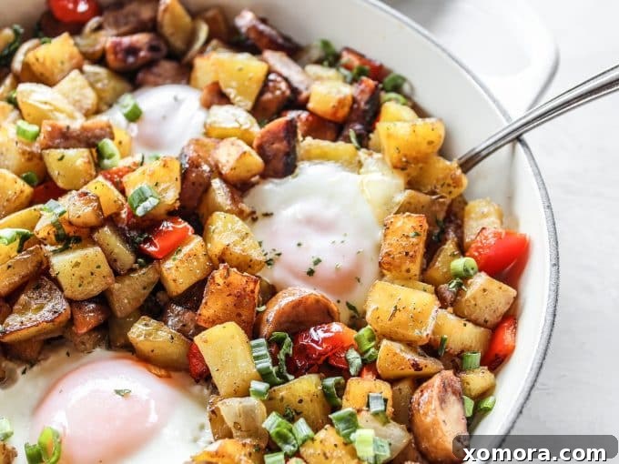 Rustic Chicken Sausage and Bell Pepper Hash 5 A serving of crispy chicken sausage and pepper hash with sunny-side-up eggs, presented in a bowl