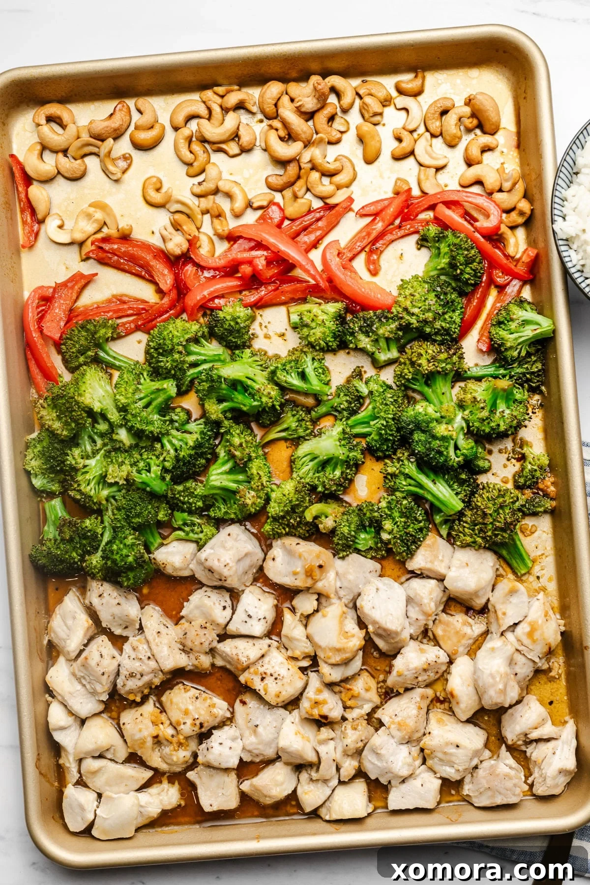 Effortless Sheet Pan Cashew Chicken 5 A close-up shot of the finished sheet pan cashew chicken, garnished with green onions and sesame seeds, ready to be served.