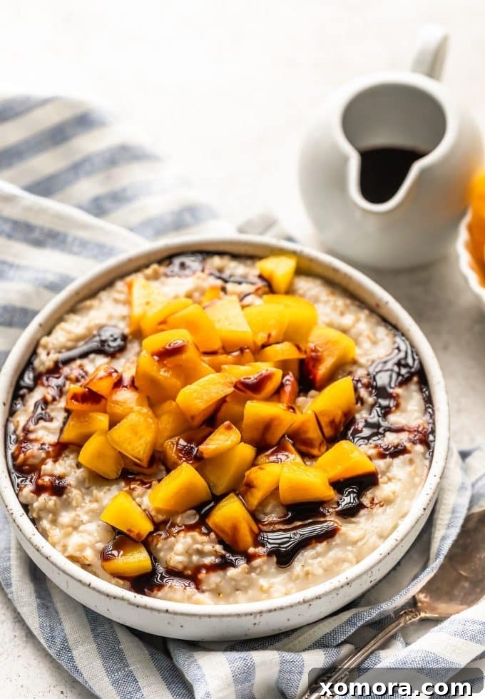 A bowl of creamy peach steel cut oats, garnished with fresh peach slices.