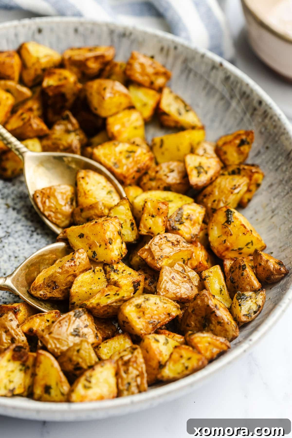Golden Air Fryer Potato Bites 2 Air Fryer Diced Potatoes in a white bowl with fresh parsley