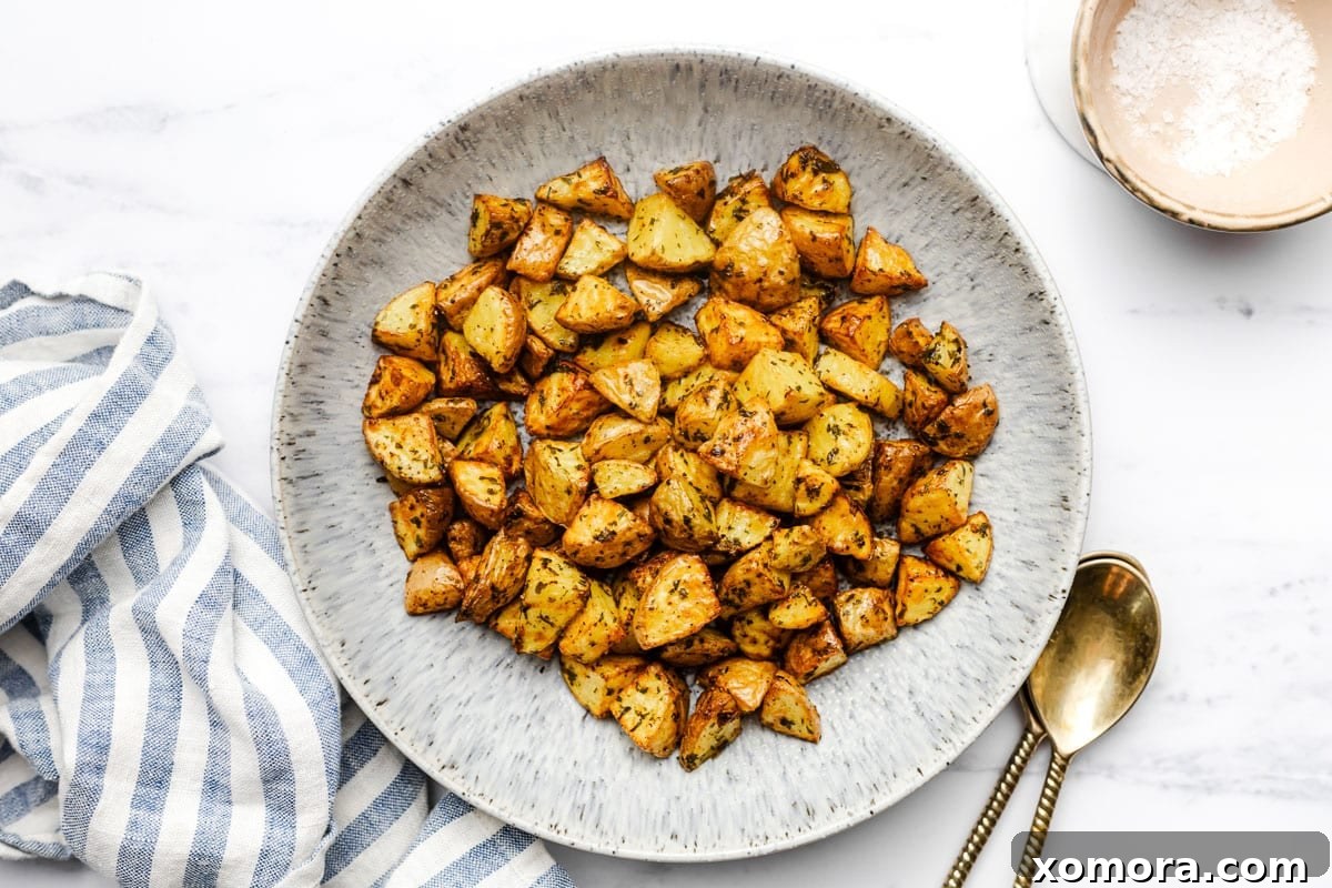 Golden Air Fryer Potato Bites 6 Air fryer potatoes served alongside a plate of chicken and green beans