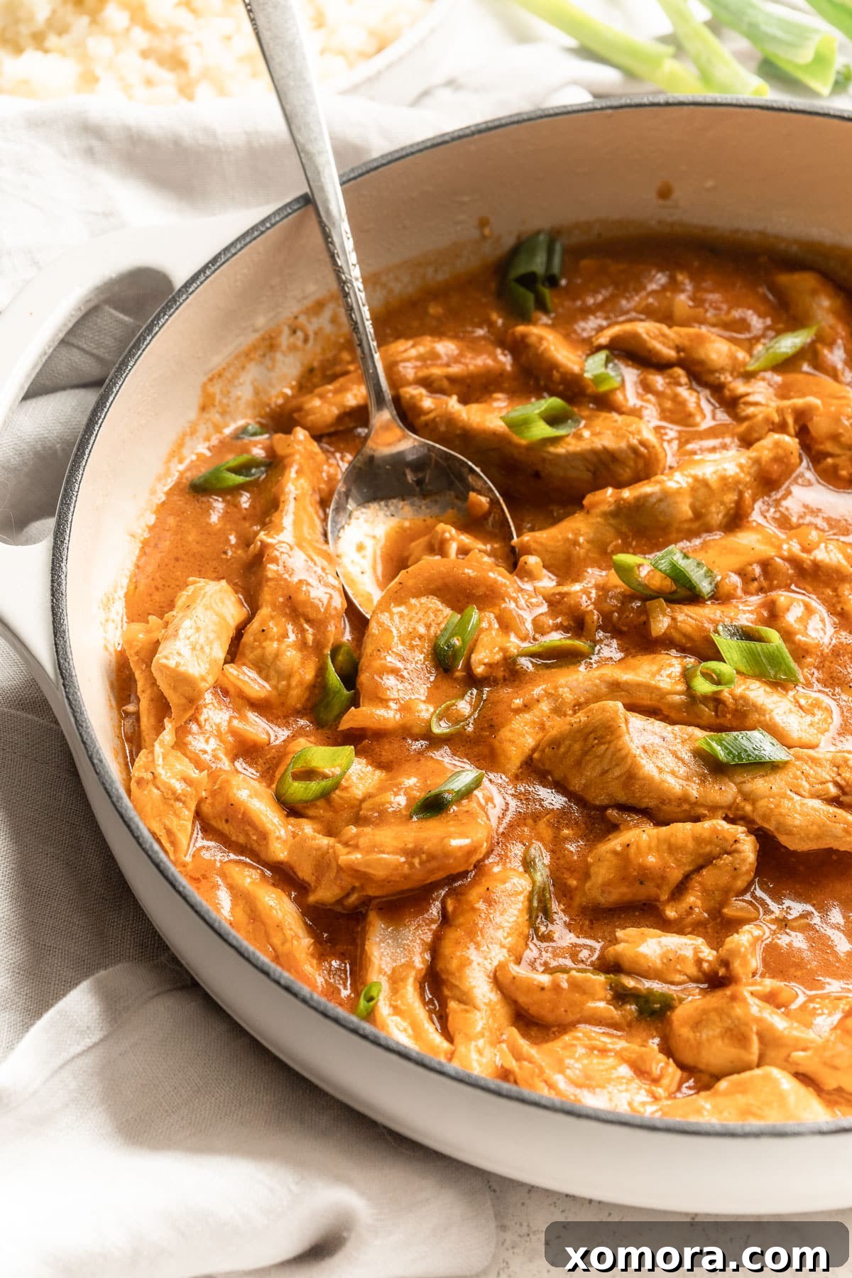 A bowl of Easy Chicken Curry garnished with fresh green onions.