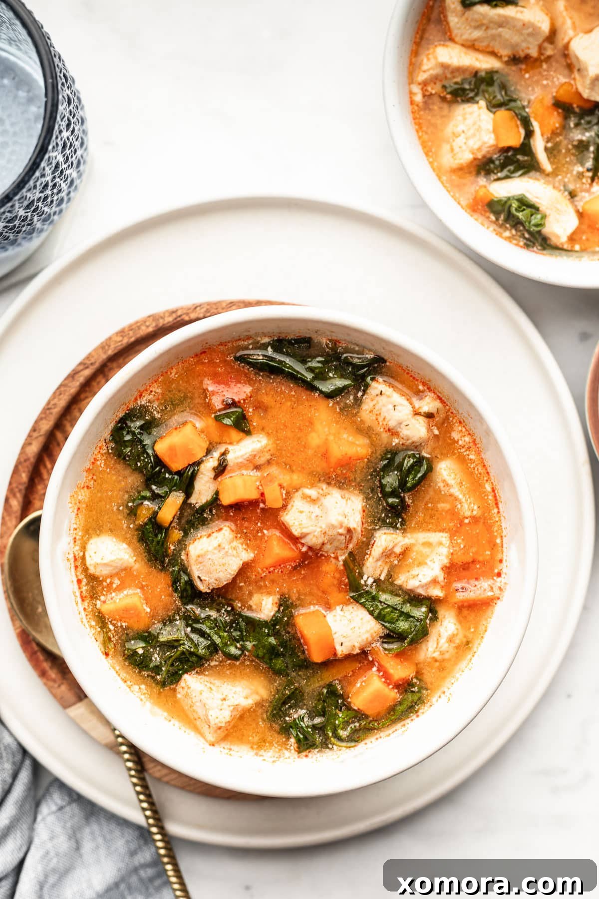 Instant Pot Tangy Buffalo Chicken Sweet Potato Soup 2 A steaming bowl of Instant Pot Buffalo Chicken Sweet Potato Soup, garnished with fresh cilantro and a drizzle of ranch dressing, ready to be enjoyed.
