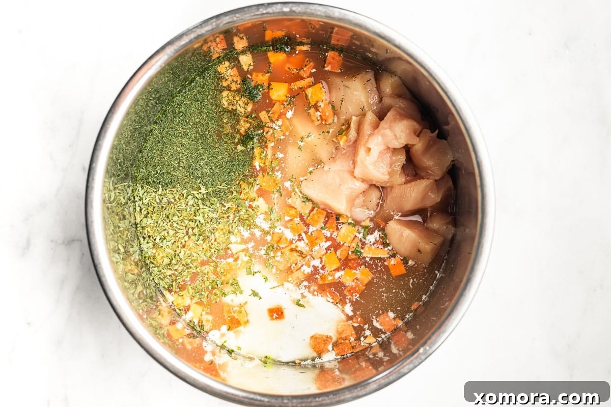 Instant Pot Tangy Buffalo Chicken Sweet Potato Soup 3 A close-up view of the vibrant Instant Pot Buffalo Chicken Sweet Potato Soup, showcasing the tender chicken, bright orange sweet potatoes, and green spinach flecks.