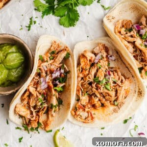 A circular image of Instant Pot Shredded Salsa Chicken, ready to be served.