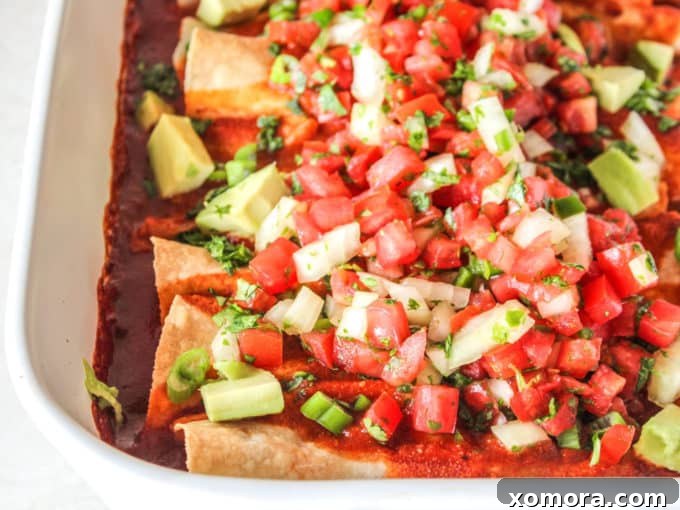 Unbelievably Creamy Dairy-Free Chicken Enchiladas 4 Finished chicken enchiladas topped with fresh pico de gallo, cilantro, and sliced avocado.