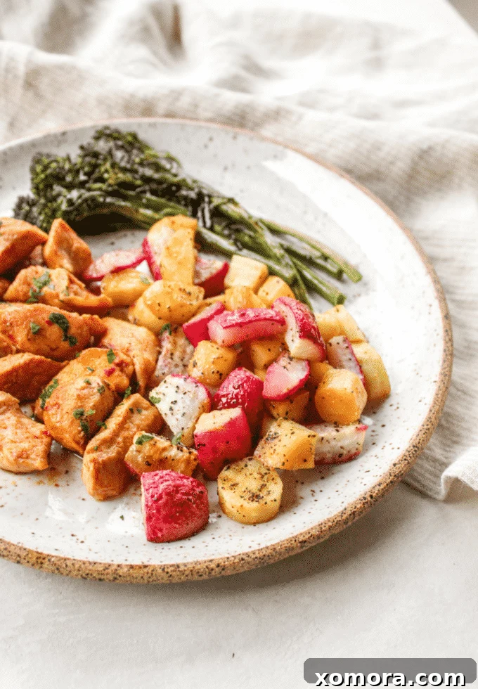 One-Pan Roasted Chicken and Broccolini 2 Close-up of a sheet pan dinner with marinated chicken, broccolini, parsnips, and roasted radishes, ready to be served.