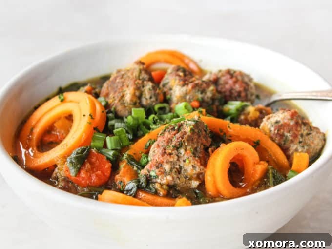 Close-up of golden-brown turkey meatballs sizzling in a soup pot with olive oil, ready to be immersed in the rich broth.