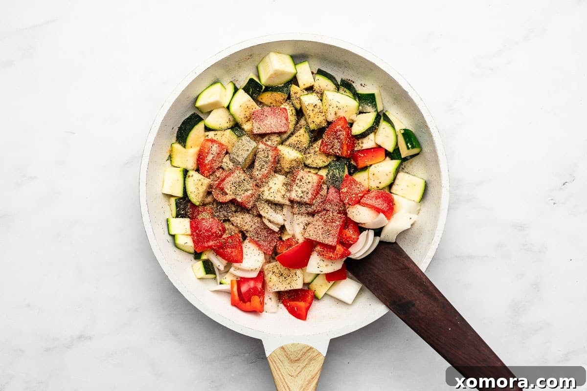 One-Pan 20-Minute Sausage and Zucchini Meal 4 A vibrant mix of sliced sausage, zucchini, bell peppers, and onions cooking in a large skillet.