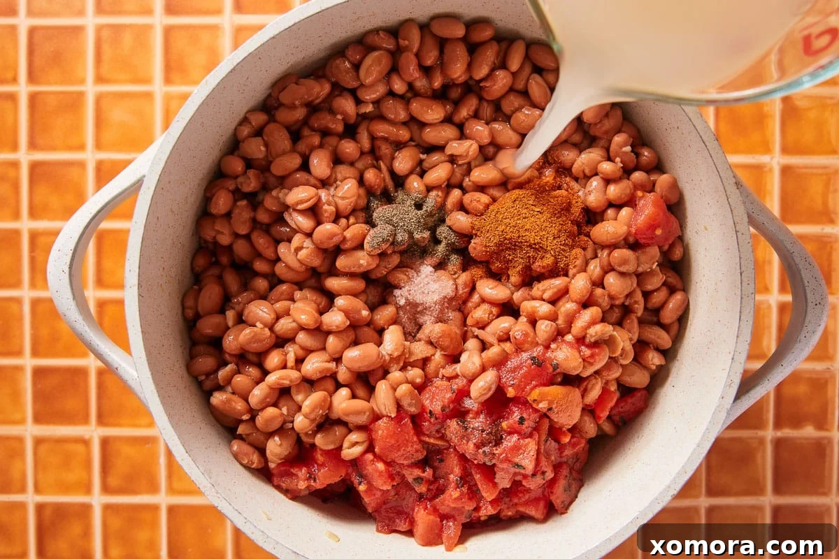 Effortless Sausage and Pinto Bean Stew 4 Assorted ingredients for sausage and pinto bean soup on a cutting board.